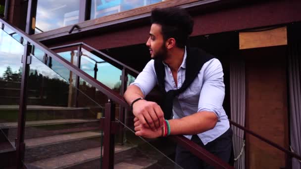 Retrato de espera Jovem Empresário Árabe Olhando para a câmera e sorrindo no fundo European Business Restaurant Stairs — Vídeo de Stock