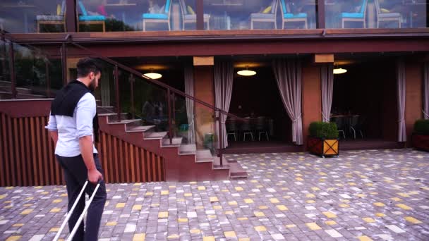 Genç Yetişkin Arap başarılı adam öğrenci geldiysen oraya restoran ile bavul için elinde, kamera, durur ve uzak görünüyor gülümseyen. — Stok video