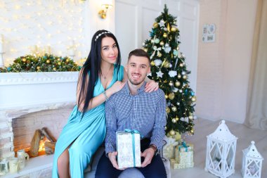 Genç çift yan yana gülümseyerek poz stüdyo oturma