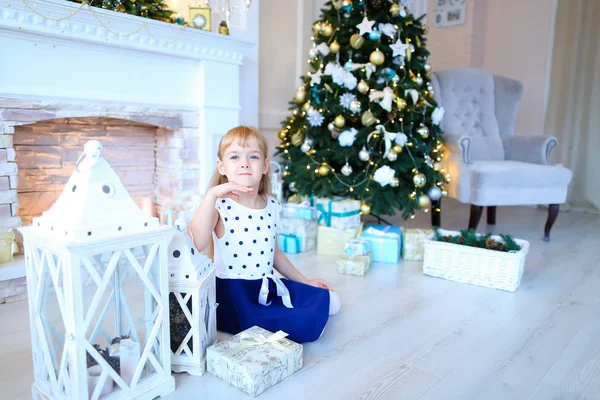 Nettes Mädchen posiert und lächelt in weißem New Year Studi in die Kamera — Stockfoto