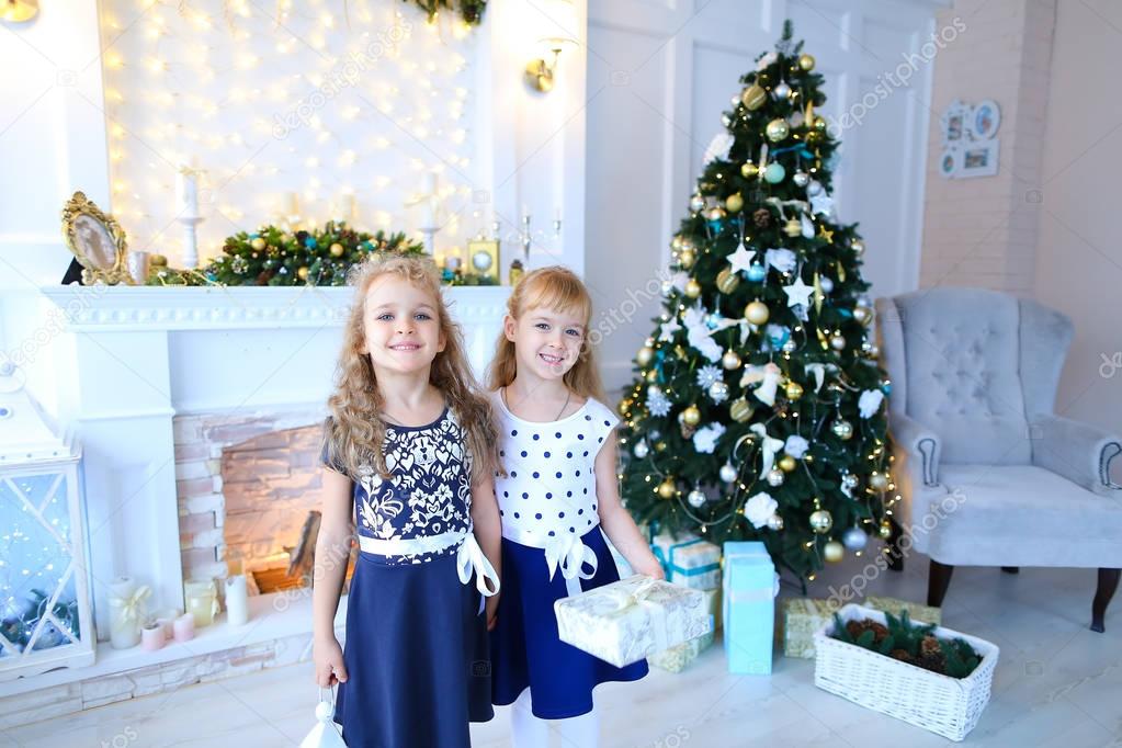 Friendly cute sisters pose for camera, hold gifts in hands , smi