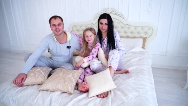 Retrato de familia feliz en pijama sonriendo y mirando la cámara en la cama — Vídeo de stock
