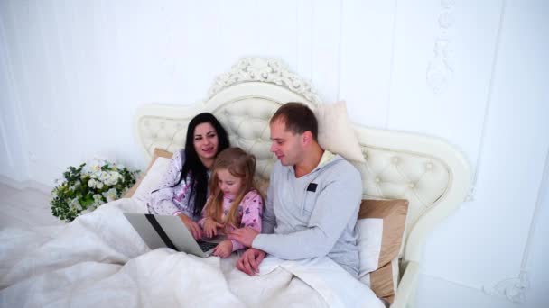 Fortgeschrittene Familie schaut gemeinsam Cartoons auf Laptop im Bett. — Stockvideo