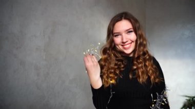 Noel ışıkları ve güzel bir gün ile kameraya bakarak gülümseyen genç güzel kız