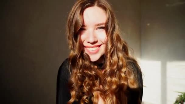Портрет девушки, смеющейся от радости, получившей удовольствие и совершенную улыбку, снятый на яркое зимнее солнце — стоковое видео