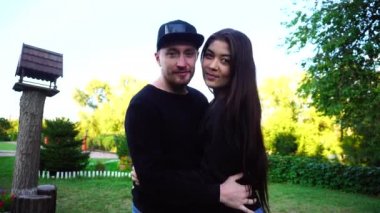 Yakışıklı genç Arapça adam kamera için poz ve ceket veya saç, düzeltiyor gülümsüyor ve merdiven arka plan açık havada etrafına bakıyor.