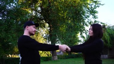 Sevgili sevimli genç kız ve birbirimizi, çocuk öpüşme ve sarılma, parkta ağaç arka plan açık havada konuşurken elele.