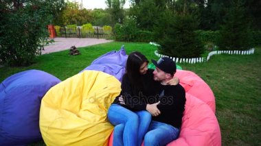 Kaç aşk Sit ve çok renkli koltuklar, gülümseyen, sarılma ve birbirimizi açık havada parkta öpüşme konuşmasında içinde.