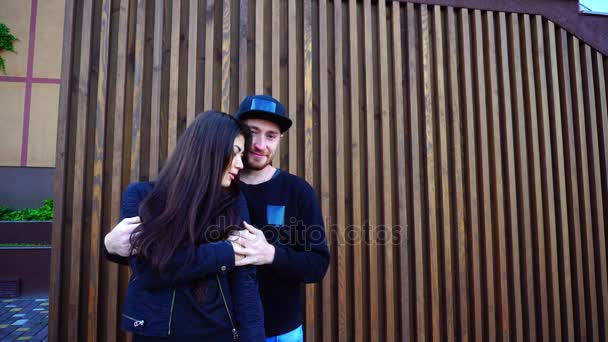 Vrouwelijke gelegen op voorplan, man achter It. verliefd houden handen en knuffelen, vrouw zegt iets aan Guy op achtergrond muur van Restaurant buitenshuis. — Stockvideo