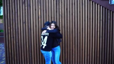 Arkadaşlığını kucaklıyor ve her diğer gördüğüme sevindim döne döne, yavaşça öpüşme ve Restoran merdiven arka plan açık havada gündüz sarılma.