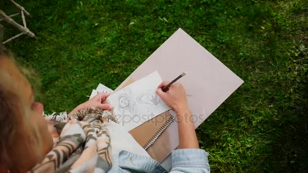 Hand of Girl Artist Makes Sure Sharp Pencil Strokes on Album Pages, que representa el retrato de Sketch de una chica desconocida. Master se sienta en el parque al aire libre . — Vídeos de Stock