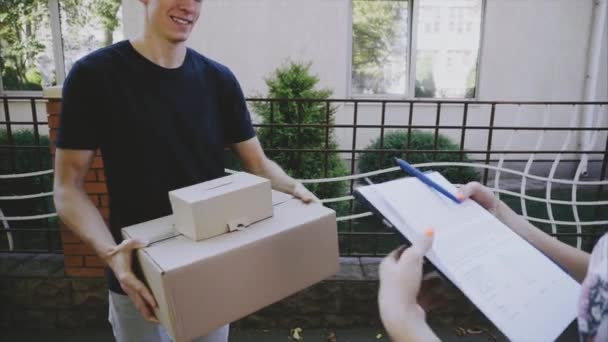 Man Courier traz ordem ao cliente, dá caneta e papel para assinar e cliente menina toma ordem e Runner folhas . — Vídeo de Stock