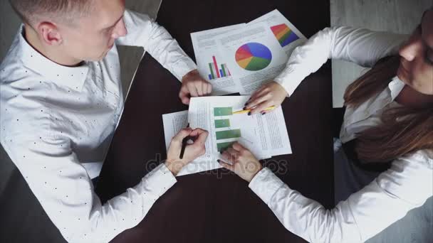 Woman Tells Man About Job, Nouvelles idées et spectacles Graphic. Ils sont assis dans le bureau de la table en bois . — Video