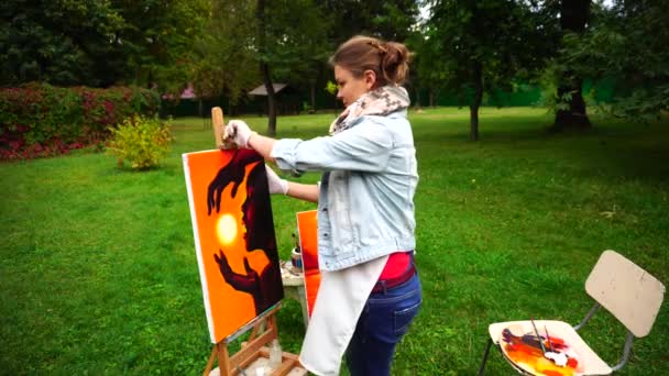 Artista donna prende pittura da anguilla e tiene, sorrisi e in piedi in piena crescita in Green Park all'aperto . — Video Stock