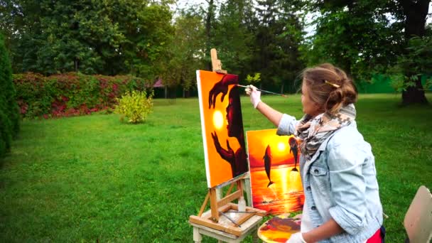 Artist Good-Looking Female Making Final Touches on Workers to Complete Picture and Sitting in Park on Background of Green Plantations Outdoors. — Stock Video