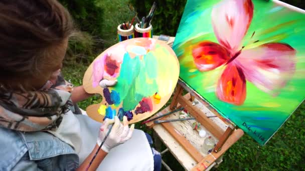 Famale artista mezcla colores al óleo para empezar a dibujar pintura en el parque al aire libre . — Vídeos de Stock