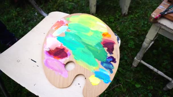 Tiro desde arriba de la paleta de madera con pinturas al óleo de colores . — Vídeos de Stock