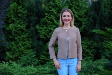 Gülümseyen ve kamera ve standları için poz çekici genç kız