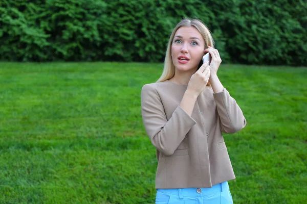 Atractiva dama rubia hablando por teléfono y lo sostiene en la mano, smi — Foto de Stock