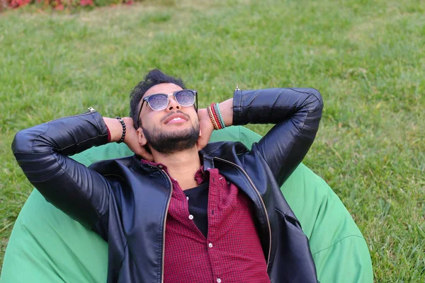 Portrait d'un jeune homme arabe, étudiant allongé sur une chaise, sourire — Photo