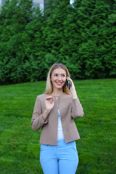 Atractiva dama rubia hablando por teléfono y lo sostiene en la mano, smi — Foto de Stock