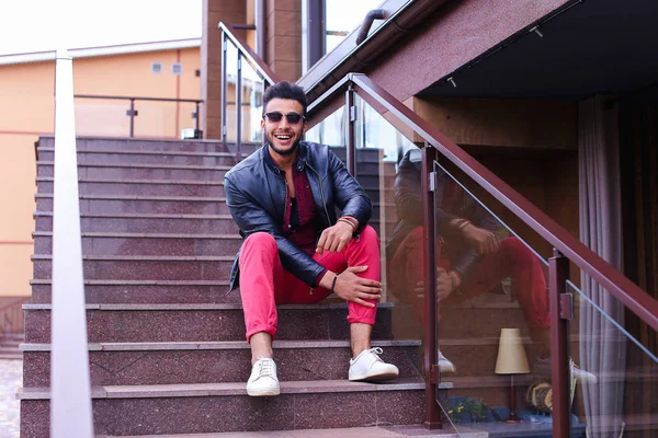 Hombre musulmán se sienta sonriendo y posando en las escaleras en el restaurante en — Foto de Stock