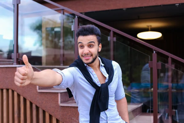 Cheerful young man looks Muslim smiling and showing hand gesture — Stock Photo, Image