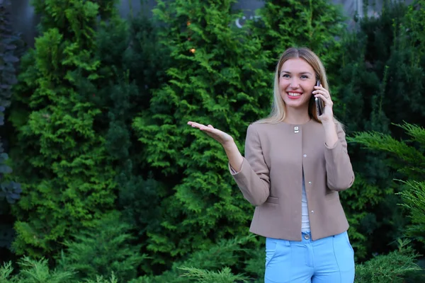 Senhora loira atraente falando ao telefone e segura na mão, smi — Fotografia de Stock