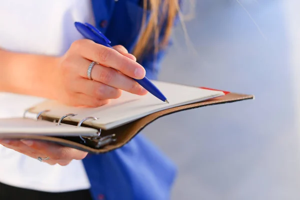 Девушка держит в руках дневник, блокнот с простынями и ручкой и бумаги — стоковое фото