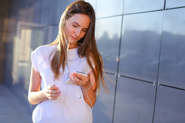 Una joven adulta bonita estudiante mujer de negocios sostiene telepho — Foto de Stock