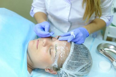 Kaşları dövme kadın efendi özel aygıt kaş üzerinde tutar.