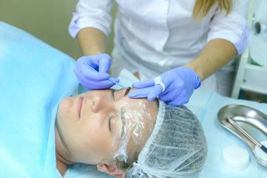 Kaşları dövme kadın efendi özel aygıt kaş üzerinde tutar.