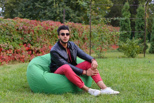 Arabian Guy Musingly guarda oltre e sorride, riposo e seduta in — Foto Stock