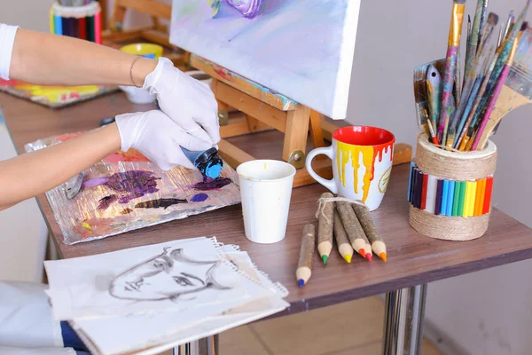 Umělec, vytáhne barvy z trubek na palety na míchání barev t — Stock fotografie