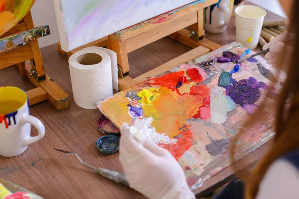Umělec, vytáhne barvy z trubek na palety na míchání barev t — Stock fotografie
