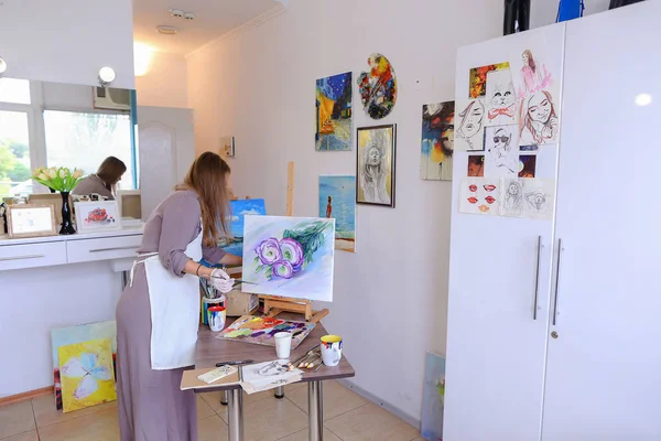Umělec dívka drží štětec v ruce a kreslí na plátně, snímá Ph — Stock fotografie