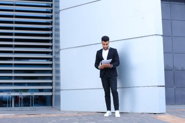 Arap girişimci adam tutar ve dikkate alır, okuma belgeleri, s