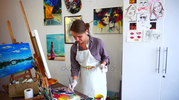 Pretty Female Artist Painting Brush and Listening Music Through Headphones and to Dance in Spacious Art Studio. — Stock Video