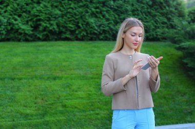 Sevimli kız cep telefonu tutan ve kullanır, gülümsüyor ve e ifade eder