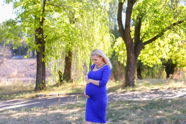 Sarışın bekleyen anne güneşli Park, Stop yürüyüş