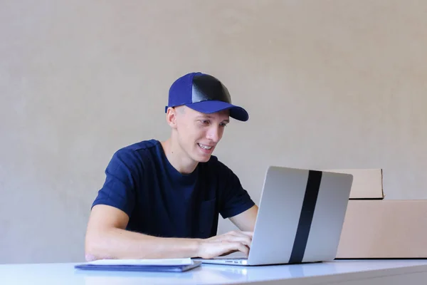 Correio sentado na mesa, digitando no computador nos Correios . — Fotografia de Stock