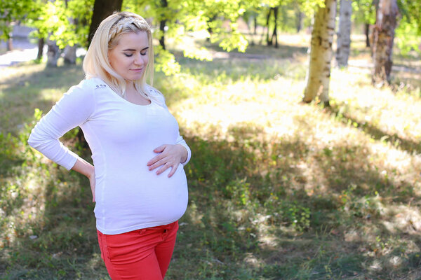 Stunning Young Pregnant Woman Gently Touching Belly and Feels Di