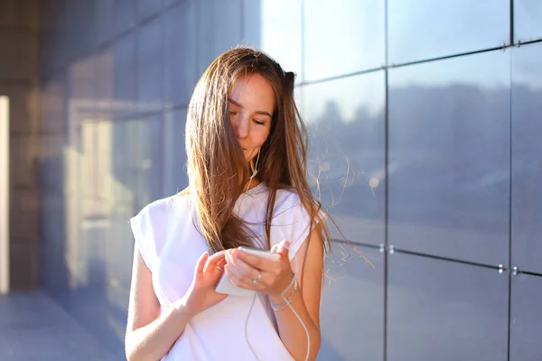 Una joven adulta bonita estudiante mujer de negocios sostiene telepho — Foto de Stock