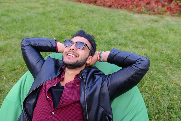 Portrait d'un jeune homme arabe, étudiant allongé sur une chaise, sourire — Photo