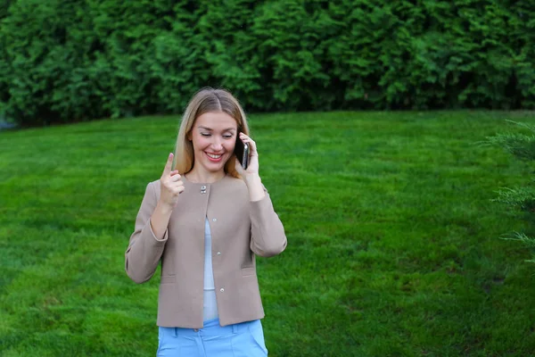 Attraktive blonde Dame telefoniert und hält es in der Hand, smi — Stockfoto