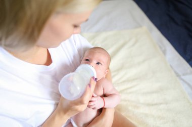 Annem kollarında tutar ve bebek şişe, yeni doğan içecekler MIL beslemeleri