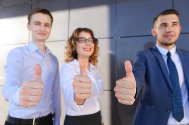 Üç güzel gösteren başparmak yukarı, gülüyor, smilin gençler