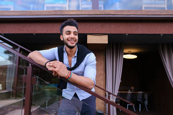 Joven sonrisa guapo masculino árabe apariencia apoyándose en el pecho ha — Foto de Stock