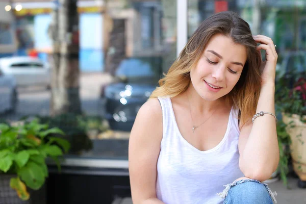 Jonge vrouw op de verdieping aan de straat kijken in de camera met behulp van p — Stockfoto