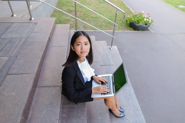 Asian beautiful young female holds in hands laptop and smiling,l